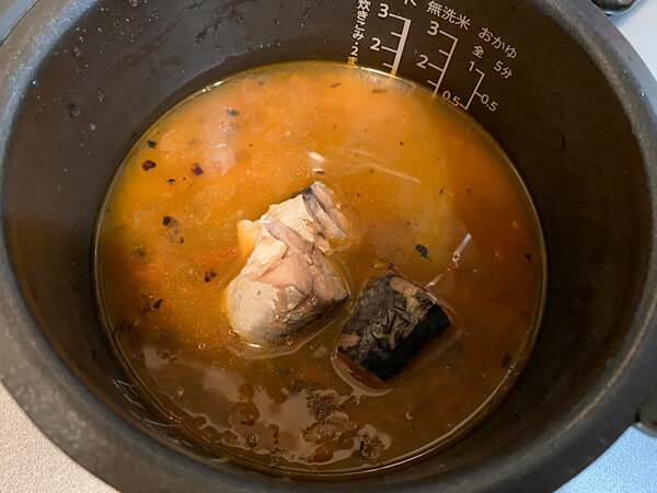 米にカレーのタネと鯖の水煮缶を入れる